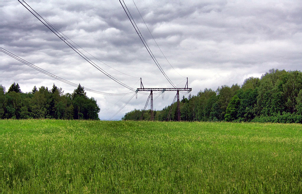 High-voltage power lines over green field illustrating electricity supply in Connecticut